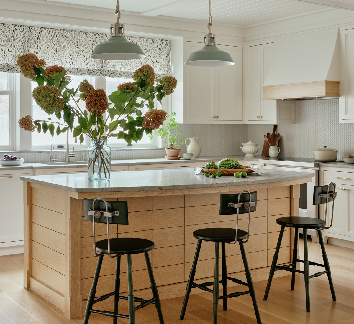 A transitional kitchen with an oak island and white cabinetry by Taste Design.