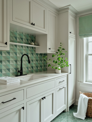 A laundry room with modern green tile backsplash.
