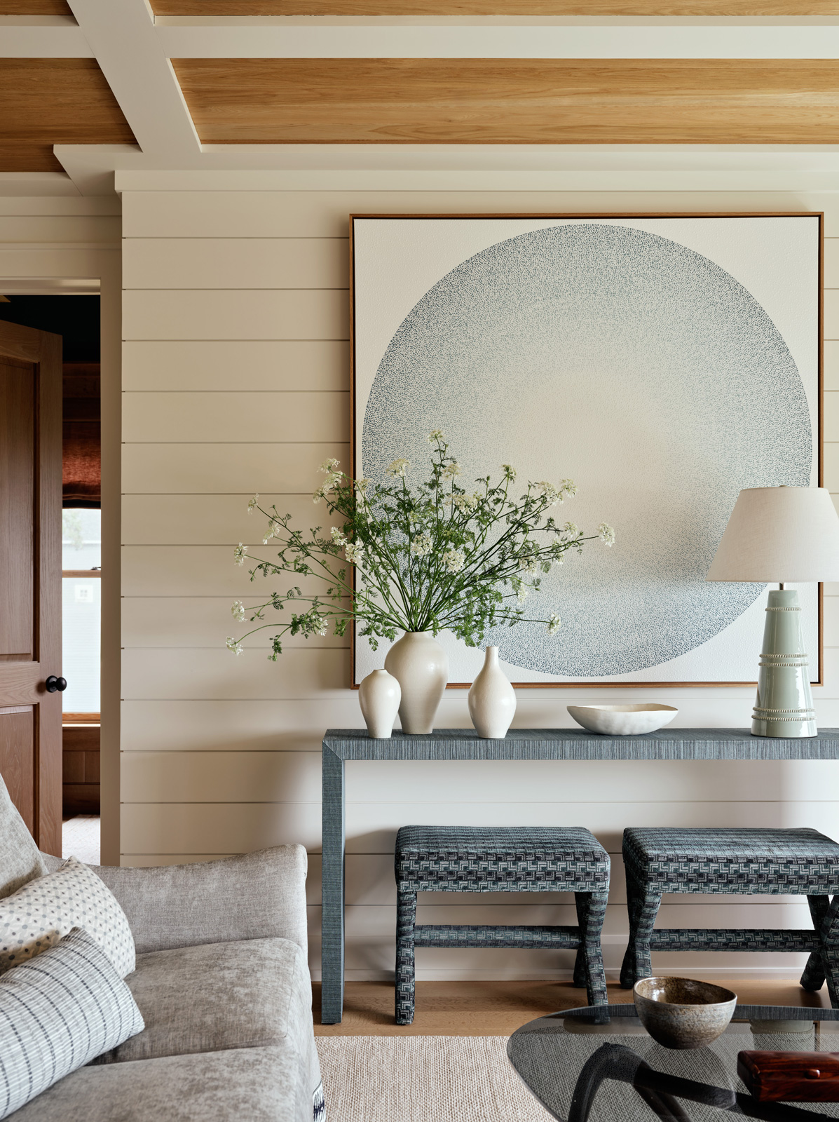 A blue living room console with original art above.
