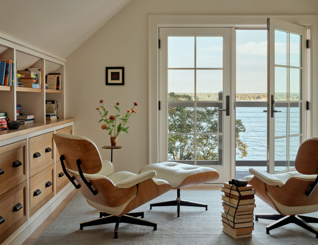 A home office with Eames chairs and a water view.