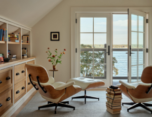 A home office with Eames chairs and a water view.