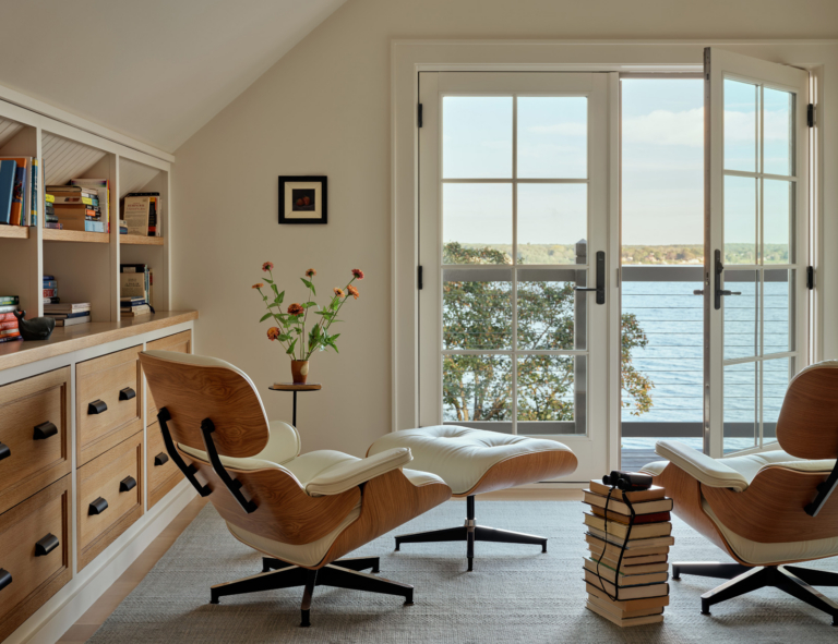 A home office with Eames chairs and a water view.