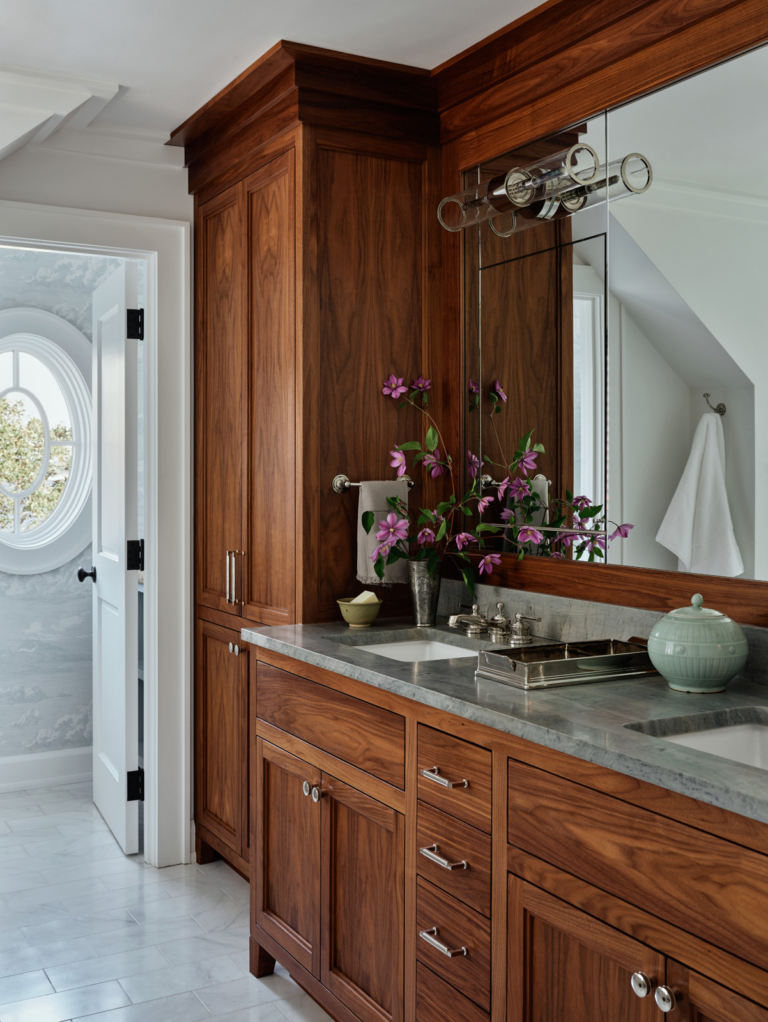 A primary bathroom with custom walnut vanity.