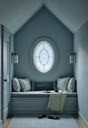 A reading nook with a window seat and blue color drench.