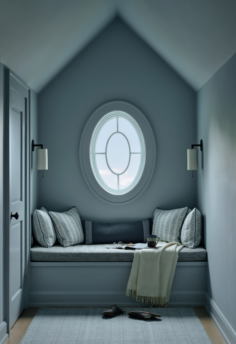 A reading nook with a window seat and blue color drench.