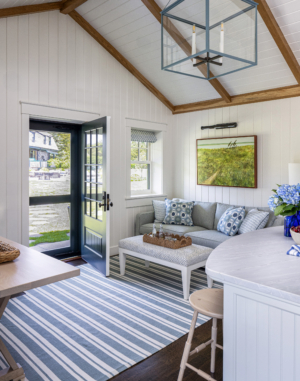 A guest house sitting area with striped rug and seating