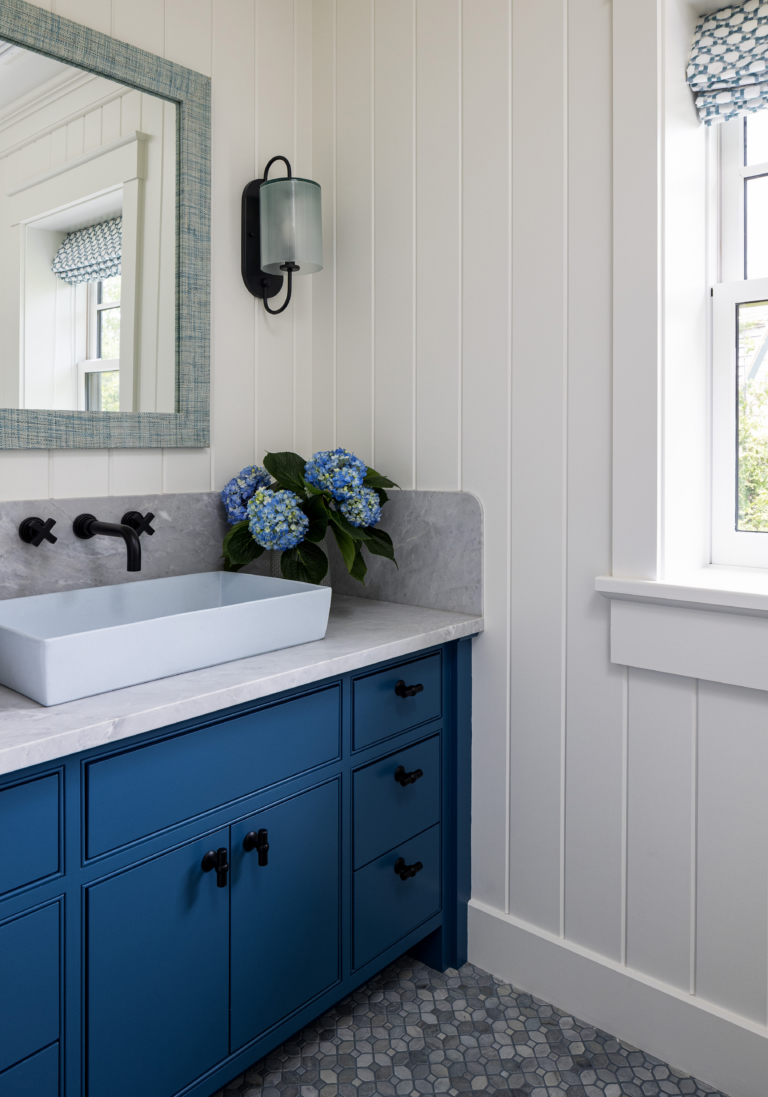 A poolhouse bathroom vanity in blue with a light blue sink by Taste Design