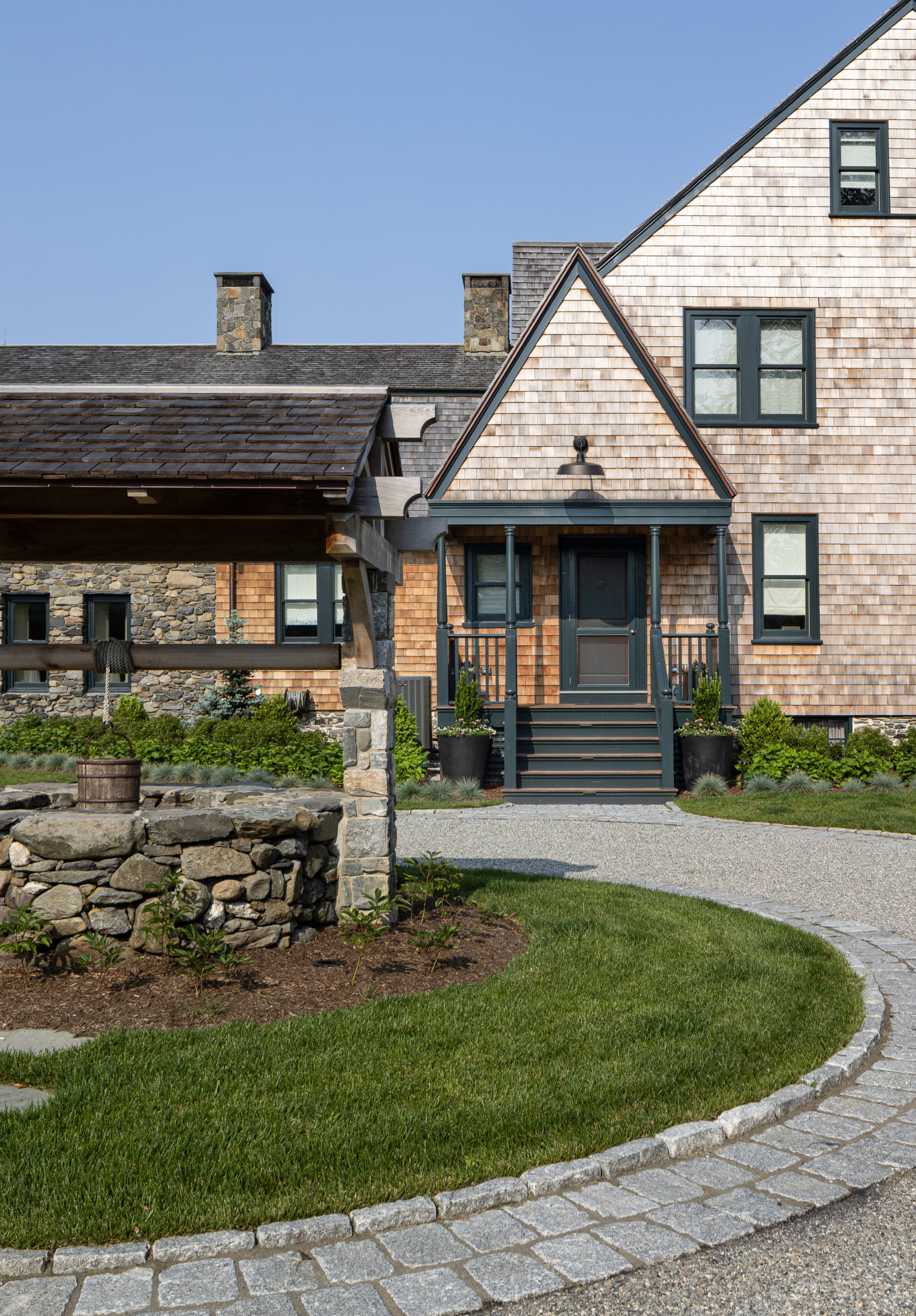A well and front of an historic shingle-style farmhouse in Jamestown Rhode Island by Taste Design