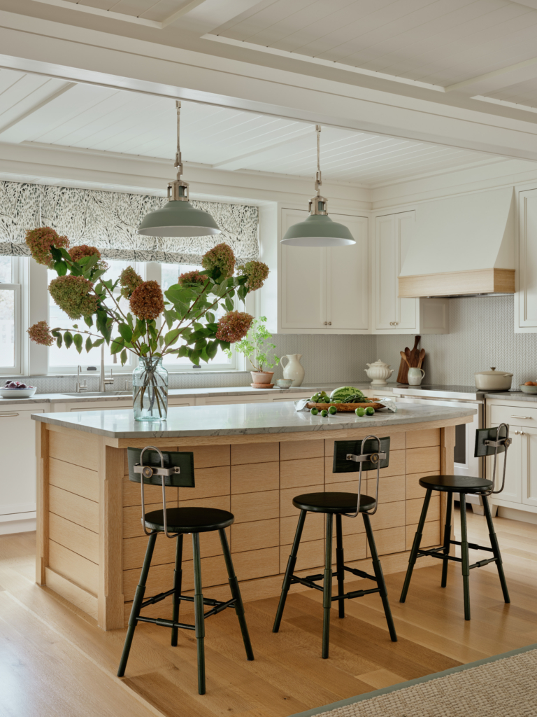 A transitional kitchen with an oak island and white cabinetry by Taste Design.